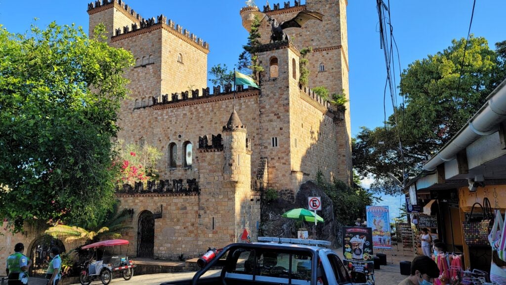 Stone castle and street in Lamas, Peru, with mototaxis parked out front